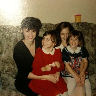 Photo of Sara Mitich along with her mother and two siblings sister wearing red dress